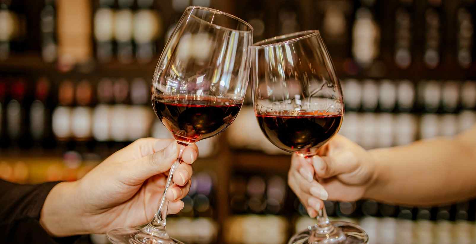 two wine glasses clinking together in winery